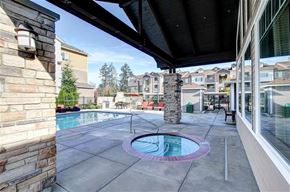 Olympia apartment for rent - A pool area with a hot tub and a stone pillar.