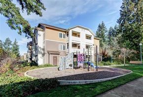 Olympia apartment for rent - A modern two-story apartment building with a playground in front.