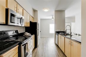 Puyallup apartment for rent - A kitchen with black appliances and wooden cabinets.