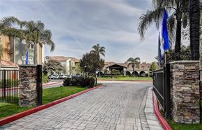 Turlock apartment for rent - A driveway with a red border leads to a gated community.