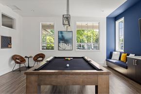 Portland apartment for rent - A pool table is in the middle of a room with a blue wall.
