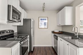 Portland apartment for rent - A kitchen with white cabinets and a black stove top oven.