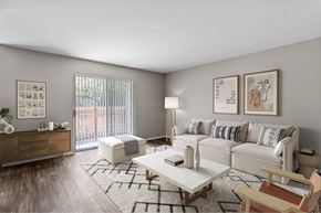 Portland apartment for rent - A living room with a white couch, a wooden chair, a coffee table, and pictures on the wall.