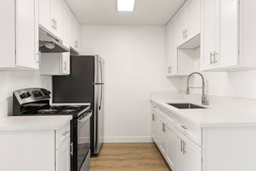 National City apartment for rent - A kitchen with white cabinets and a black refrigerator.