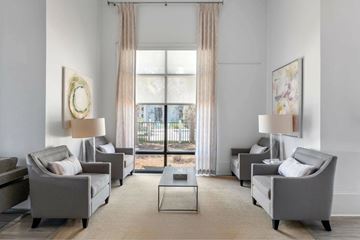 Destin apartment for rent - A living room with grey couches and a large window.