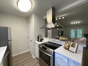 Raleigh apartment for rent - A modern kitchen with a stove top oven and a refrigerator.