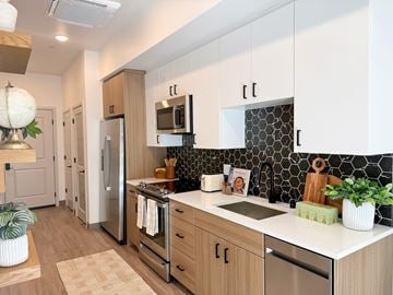 Sacramento apartment for rent - A kitchen with wooden cabinets and a black and white backsplash.