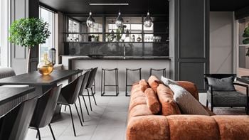 A modern living room with a long couch and a dining table.
