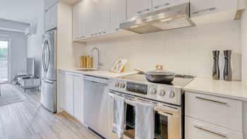 A modern kitchen with a stainless steel refrigerator and a stove top oven.