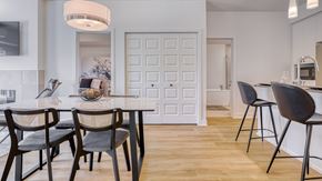 Gatineau apartment for rent - A modern dining room with a white door and a wooden table.