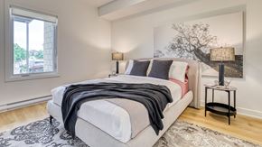 Gatineau apartment for rent - A bedroom with a large bed and a painting on the wall.