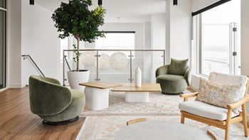 A living room with a green chair and a white table.