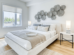 Gatineau apartment for rent - A bedroom with a large bed and a decorative wall piece.