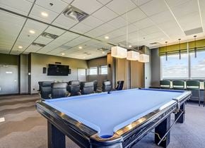 Ottawa apartment for rent - A pool table in a room with a television and chairs.