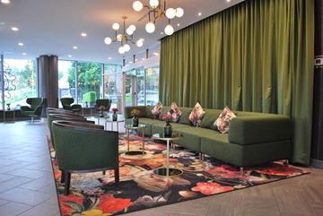 Ottawa apartment for rent - A living room with a green couch and a floral rug.