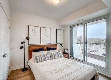 Ottawa apartment for rent - A bedroom with a large bed and a view of the outside.