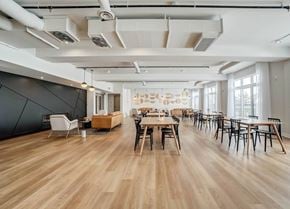 Ottawa apartment for rent - A spacious room with wooden floors and tables set up for a meeting.