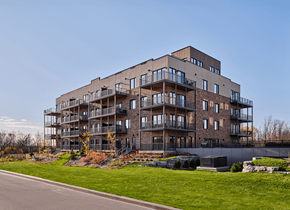 Gatineau apartment for rent - A large, modern building with many balconies and a green lawn in front at Champlain Village Urbain Apartments , Gatineau, QC, J9H 0K9
