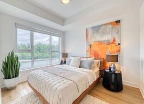 Gatineau apartment for rent - A bedroom with a large bed, a potted plant, and a painting on the wall. at Château golf, Gatineau Quebec