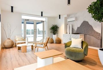 Gatineau apartment for rent - A living room with a green chair and a white couch.