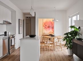 Gatineau apartment for rent - A modern kitchen with a white island and wooden chairs. at Château golf, Gatineau Quebec