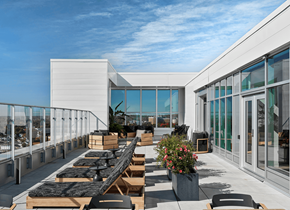 Gatineau apartment for rent - A modern outdoor dining area with wooden tables and chairs. at Le ColumbiaApartments , Gatineau, QC, J8Y 0A8