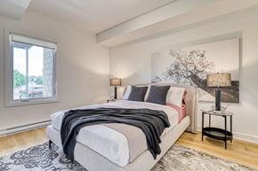 Gatineau apartment for rent - A bedroom with a large bed and a painting on the wall.