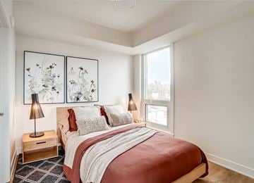 Ottawa apartment for rent - A bedroom with a large bed and two lamps.
