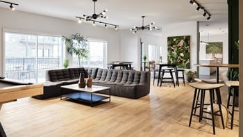 A modern living room with a pool table and a bar area.