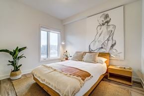 Gatineau apartment for rent - A bedroom with a large bed and a large drawing of a woman on the wall.