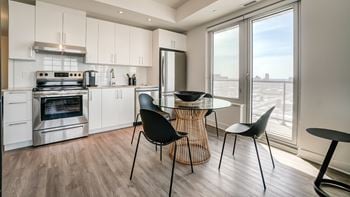 A modern kitchen with a dining table and chairs.