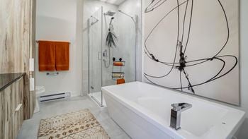 A bathroom with a white tub and a shower with a glass door.