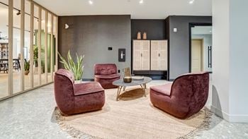 A living room with a red chair and a brown rug.