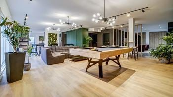 A modern living room with a wooden floor and a long wooden table.