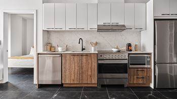 A modern kitchen with a marble backsplash and wooden cabinets.