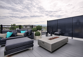 Gatineau apartment for rent - A modern outdoor seating area with a grey couch and a concrete coffee table.