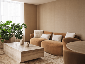 Ottawa apartment for rent - A living room with a brown sofa, a coffee table, and a potted plant.
