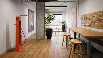 A room with a wooden floor and a long table with stools.