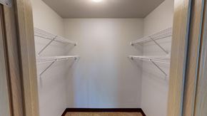 Madison apartment for rent - A walk-in closet with white shelves and a wooden floor.