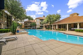 Arlington apartment for rent - A swimming pool surrounded by a tiled patio and buildings.