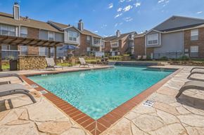 Bedford apartment for rent - A swimming pool surrounded by a stone border and lounge chairs.