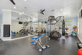 Arlington apartment for rent - A spacious gym with a variety of equipment including a treadmill, weights, and a bench press.