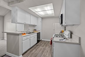 Claremont apartment for rent - A kitchen with white cabinets and a grey counter top.