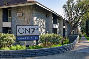 Upland apartment for rent - Apartment complex with a sign that says "On 7th Apartments"