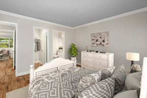 Orange apartment for rent - A bedroom with a large bed and a white dresser.