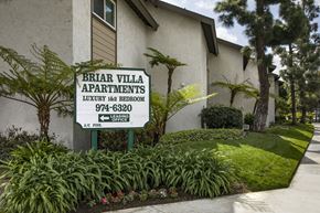 Orange apartment for rent - A sign for Briar Villa Apartments is in front of a building.