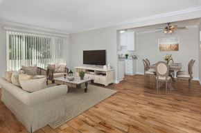 Orange apartment for rent - A living room with a couch, a coffee table, and a television.
