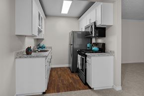 Huntington Beach apartment for rent - A kitchen with white cabinets and a black refrigerator.