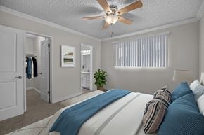 Huntington Beach apartment for rent - A bedroom with a bed, pillows, a ceiling fan, and a window with blinds.