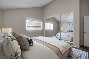 Whittier apartment for rent - A bedroom with a large bed and a mirrored closet door.